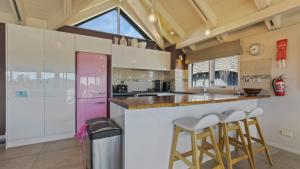 uma cozinha com armários brancos e um frigorífico rosa em 1-8 Hot Plate em Mount Hotham