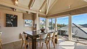 a dining room with a table and chairs and a large window at 1-8 Hot Plate in Mount Hotham