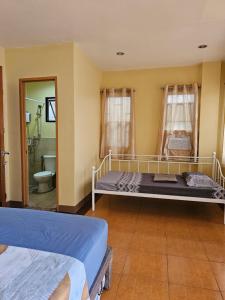 a bedroom with two beds and a bathroom at Astra Bella Apartment - Unit 4 in Dumaguete