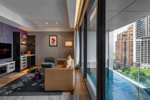 a living room with a view of a pool at Imperial Lexis Kuala Lumpur in Kuala Lumpur