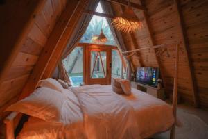 1 dormitorio con 1 cama en una cabaña de madera en شاليه ايفالو, en Al Hofuf