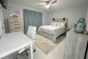1 dormitorio con 1 cama, 1 mesa y 1 jarrón en Home Away From Home, en Vero Beach