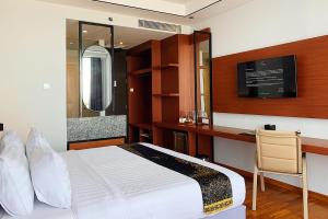 a hotel room with a bed and a desk at Grand Miami Hotel in Malang