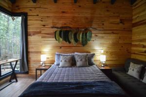 マサミトラにあるCabaña Cedrelaの木製の壁のベッドルーム1室(ベッド1台付)
