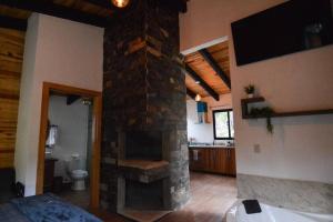 マサミトラにあるCabaña Cedrelaの家の中のリビングルーム(石造りの暖炉付)