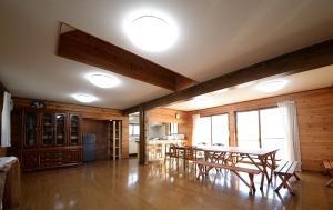 ein Esszimmer mit einem Tisch und einer Küche in der Unterkunft のんびれっじ　ハイランド館 in Nasu