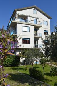 - un grand bâtiment blanc avec des balcons et des arbres dans l'établissement Appartamenti Ancora Azzurra, à Deiva Marina