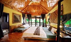 a bedroom with a large bed with a wooden ceiling at Duân Thảo homestay in Hòa Bình