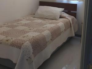 a bed with a brown and white blanket and a pillow at HOSTAL DIEGO DE ALMAGRO in Diego de Almagro