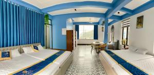 two beds in a room with blue walls at Hương Trà Villa - Hotel Tam Đảo in Tam Ðảo