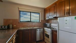 a kitchen with a white refrigerator and a window at 1750 Hotham 12 in Mount Hotham +5 photos