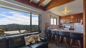 a kitchen with a couch and a large window at 1750 Hotham 12 in Mount Hotham