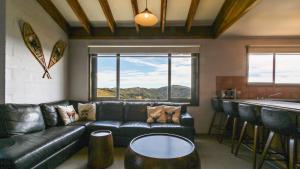 a living room with a leather couch and a bar at 1750 Hotham 12 in Mount Hotham