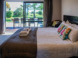 1 dormitorio con 1 cama grande y vistas a un patio en Paroa Hotel en Greymouth