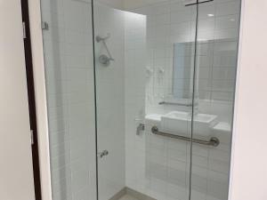 a bathroom with a glass shower with a sink at Mary MacKillop Place in Sydney