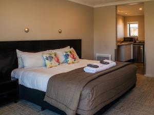 a bedroom with a large bed with towels on it at Paroa Hotel in Greymouth