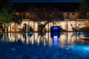 a swimming pool at night with a blue light at Lario Resort Sigiriya in Sigiriya