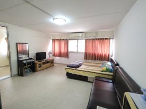 a bedroom with a bed and a desk and a television at ป็อปปูล่าคอนโด เมืองทองใกล้อิมแพค สะดวกสบาย in Ban Bang Phang