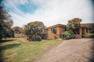a brick house with a yard and a driveway at Port Bayou House in Port Campbell