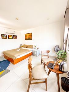 1 dormitorio con 1 cama, mesa y sillas en Hồng Châu Hotel, en Da Nang