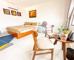 1 dormitorio con cama, escritorio y silla en Hồng Châu Hotel, en Da Nang
