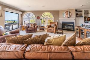 a living room with a brown couch and a fireplace at Spacious Beautiful Home with Stunning Bay Views in San Diego