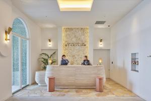 two women standing at a reception desk in a lobby at THE SENAGAJIMA STORYLINE in Tomigusuku +85 photos