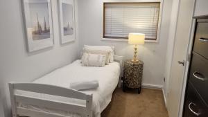 a small white bedroom with a bed and a lamp at Brockhoff Lachen in Mount Hotham