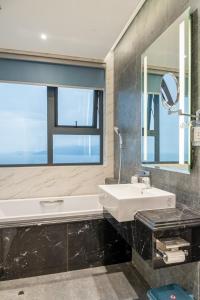 a bathroom with a sink and a mirror at Altara Quy nhơn Residences Wins in Quy Nhon