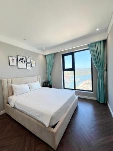 a bedroom with a large bed and a large window at Altara Quy nhơn Residences Wins in Quy Nhon