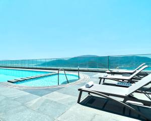 a swimming pool with lounge chairs on top of a building at Altara Quy nhơn Residences Wins in Quy Nhon