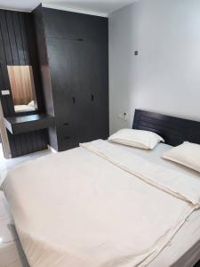 1 dormitorio con 1 cama blanca grande y cabecero negro en PND apartment 코너룸 한국식 콘도 en Vientián