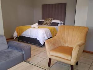 1 dormitorio con 1 cama, 1 silla y 1 sofá en 30 on Bergh, en Louis Trichardt