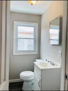 La salle de bains est pourvue de toilettes, d'un lavabo et d'une fenêtre. dans l'établissement Niagara View Inc LaSalle Av 3+Bd R,1.5 Bth, Parkng, à Niagara Falls