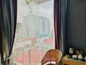 een kamer met een raam met uitzicht op de stad bij Le Grand Hanoi Hotel - The Sun in Hanoi