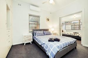 a bedroom with a bed and a mirror at 6 BR House Near Adelaide Airport in West Richmond
