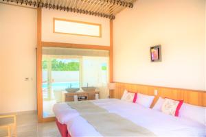 sypialnia z łóżkiem i dużym oknem w obiekcie コーラルテラス石垣島 w mieście Fukai
