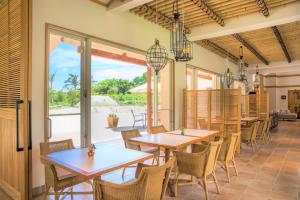 Fukai的住宿－コーラルテラス石垣島，一间带桌椅的用餐室和一个庭院