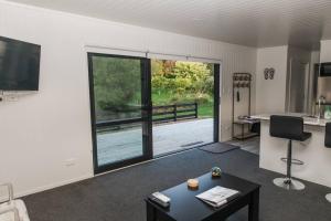 a living room with a large window and a desk at Bombay Hills Modern Retreat in Auckland