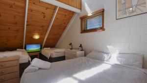 a bedroom with two beds and a television in it at Fountains 6 in Mount Hotham