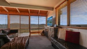 a living room with leather couches and windows at Fountains 6 in Mount Hotham