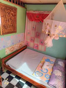 Cama pequeña en habitación con ventana en A. Zaragosa Lodging House, en Inandeng