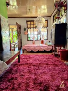 InandengにあるA. Zaragosa Lodging Houseのベッド付きの客室内に大きな赤い敷物