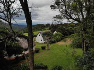 Siteki的住宿－Mabuda Guest Farm，一座白色的山丘房子,有绿色的庭院