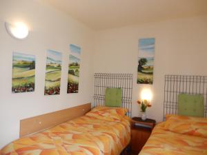 two beds in a room with paintings on the wall at Pokoje goscinne Monika in Władysławowo