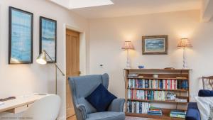 um quarto com uma secretária, uma cadeira e uma estante de livros em Long Shed Cottage em Thirsk