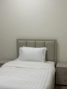a white bed with white sheets and pillows at MFAPARTMENT in Al Budayyiâ€˜