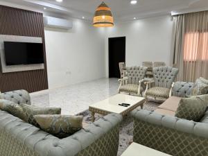 MFAPARTMENT في Al Budayyiâ€˜: غرفة معيشة مع كنب وتلفزيون بشاشة مسطحة