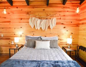 um quarto com uma cama numa parede de madeira em Cabaña Mirtus em Mazamitla