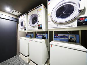 a laundry room with three washing machines and a washer and dryer at MIMARU Tokyo Akasaka in Tokyo